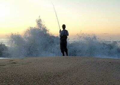 砂浜で釣りをする人